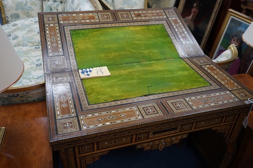 A 19th century Damascus mother of pearl, bone, and marquetry inlaid folding games table, with card, backgammon and chess surfaces, width 94cm, depth 47cm, height 85cm